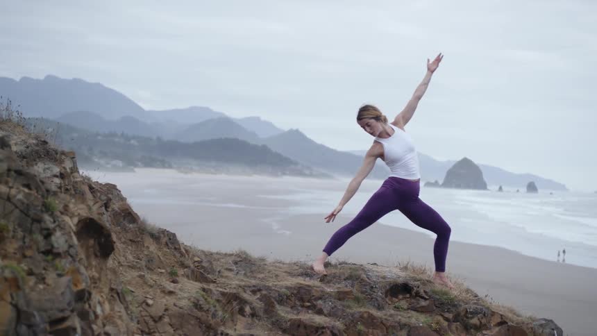 A woman does yoga on the beach