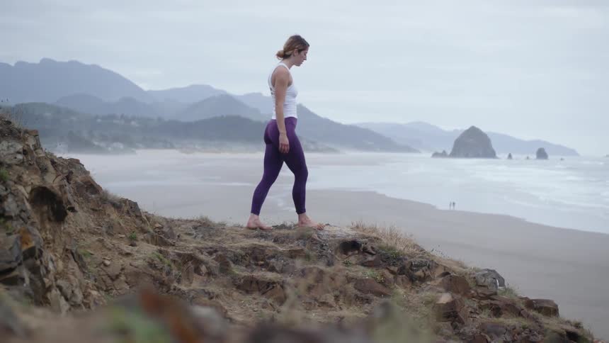 A woman walks on the rocks