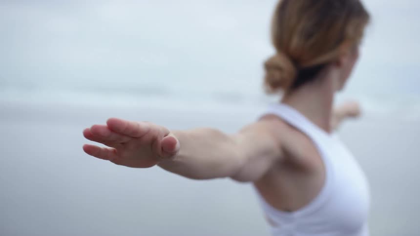 A woman doing yoga on the beach