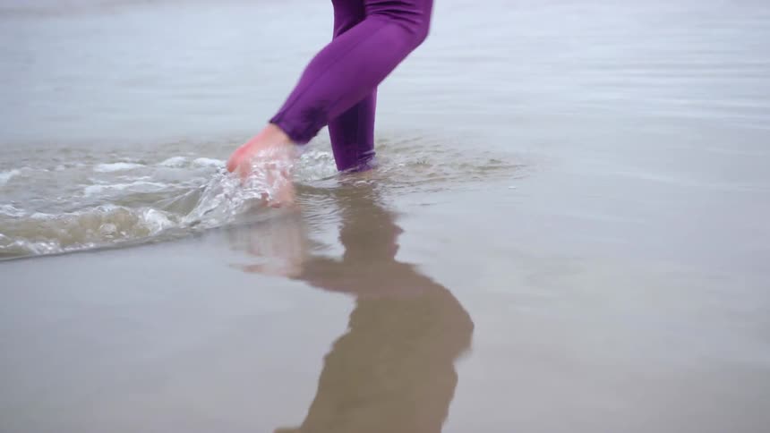 A woman walks through the water