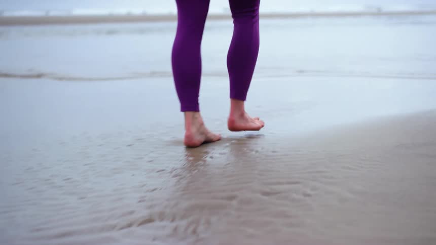 A woman is walking on the beach