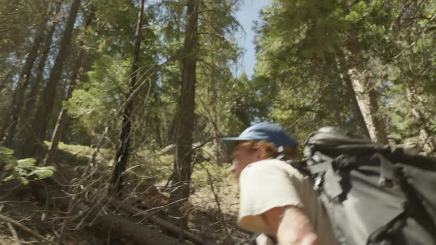A man is hiking up a steep hill