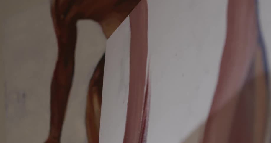 A person paints on canvas with a brush