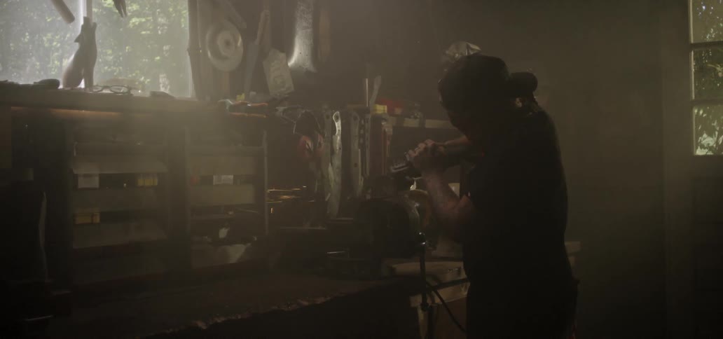 A craftsman uses a grinder on a piece of metal which causes sparks to shoot everywhere