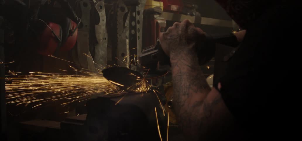 Sparks fly as man polishes blade edge