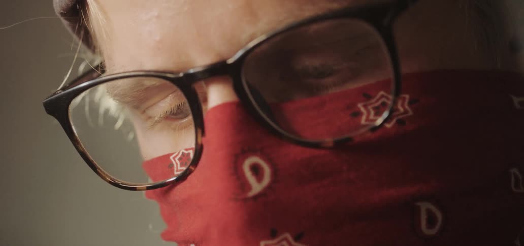 A man wears a bandana over his mouth and nose