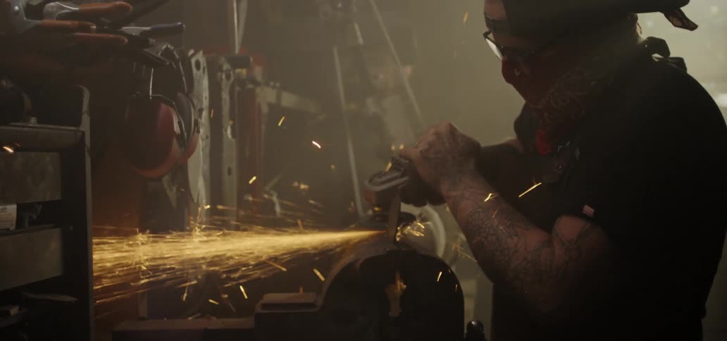 A man grinds and sands metal