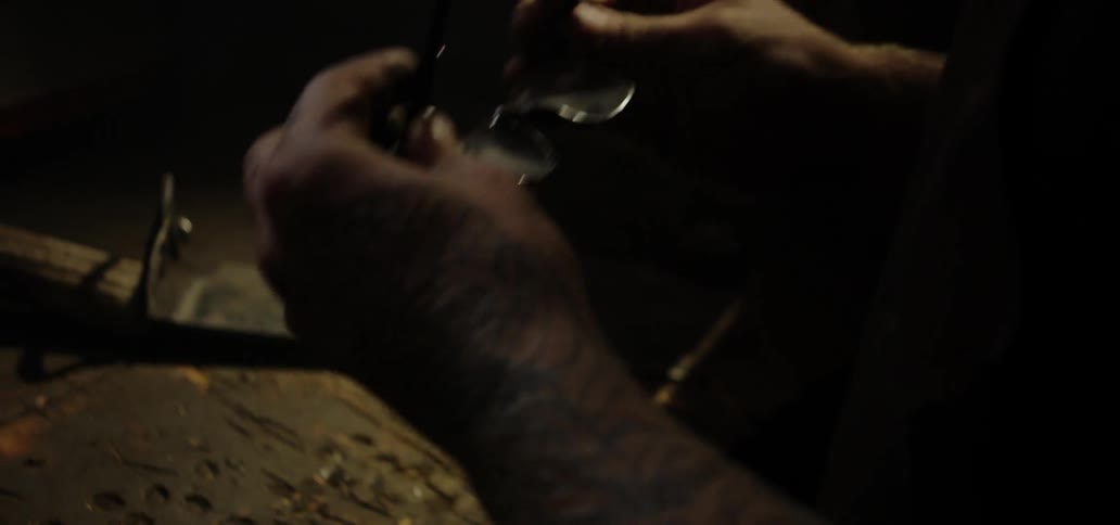 A man is putting on his glasses in a workshop
