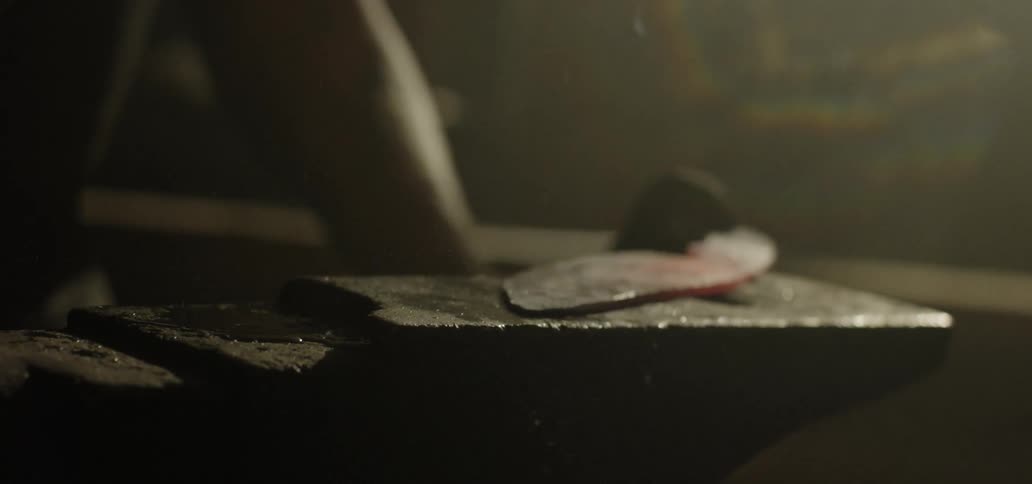 Metal worker hammering iron on metal surface