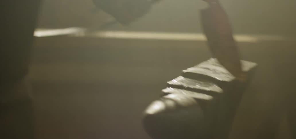 A young man hammers hot metal