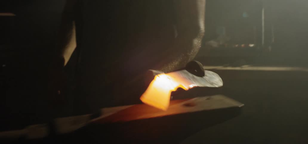 A man pulls iron out of the fire and hits it