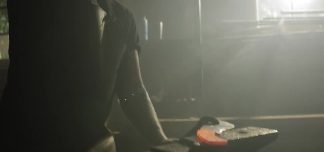 A man uses a mallet to hit a piece of red hot iron