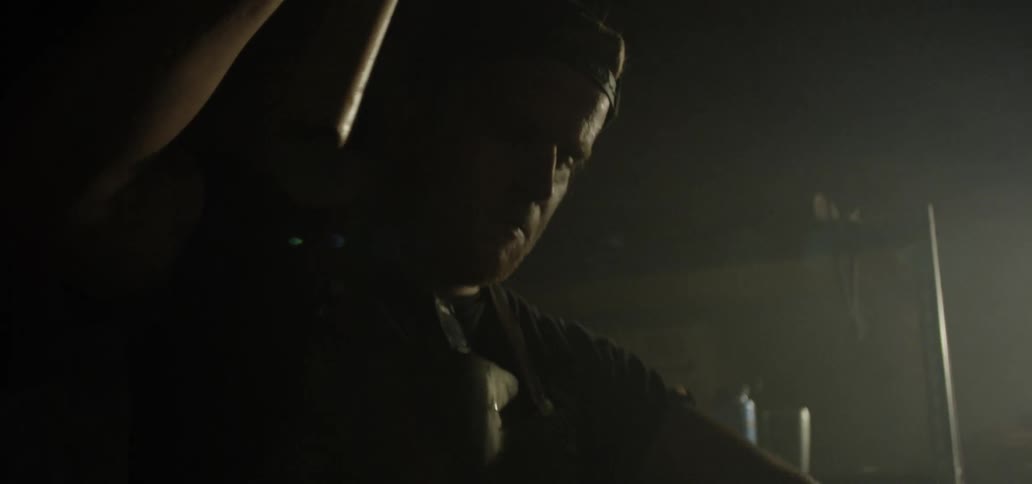 A man hammers a red hot piece of metal