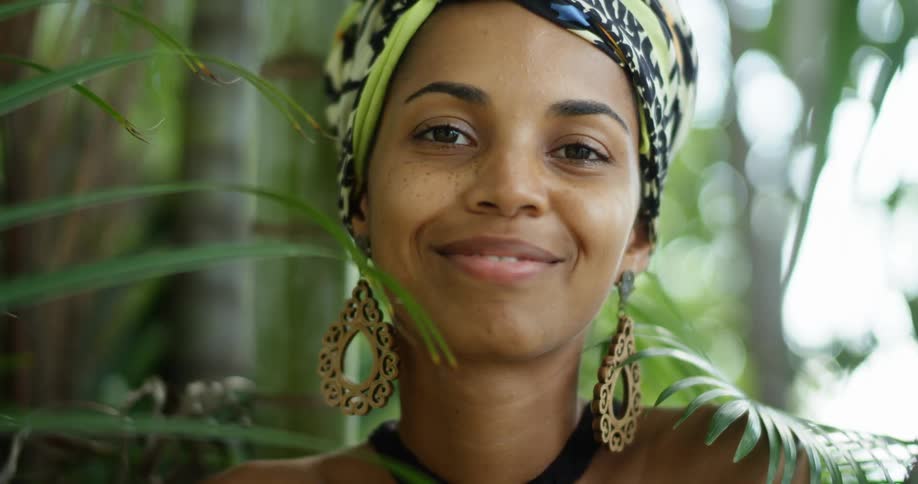 A woman in looks seriously at the camera and then laughs