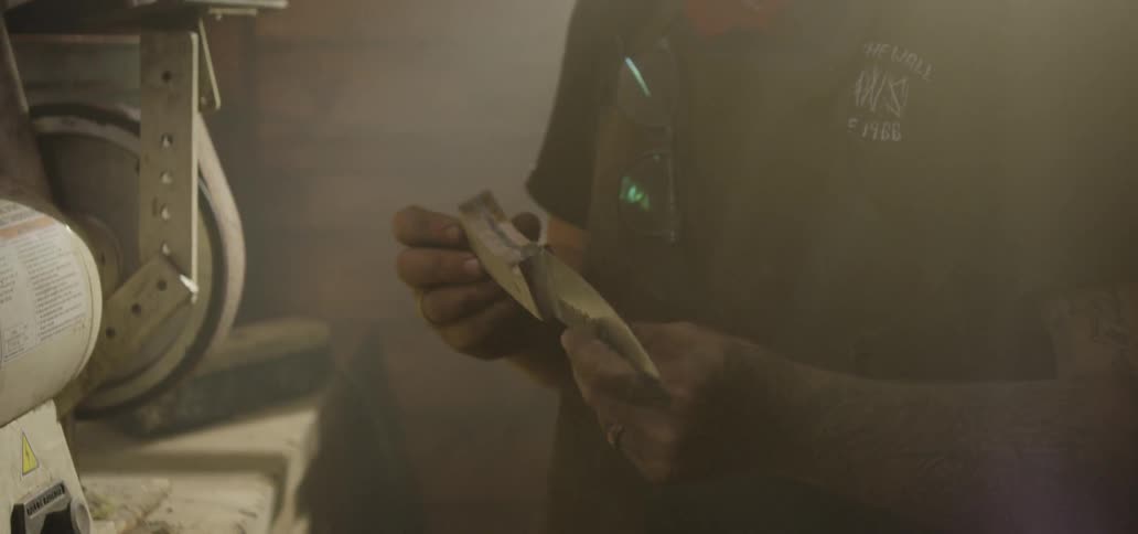 A person holding and looking at a knife