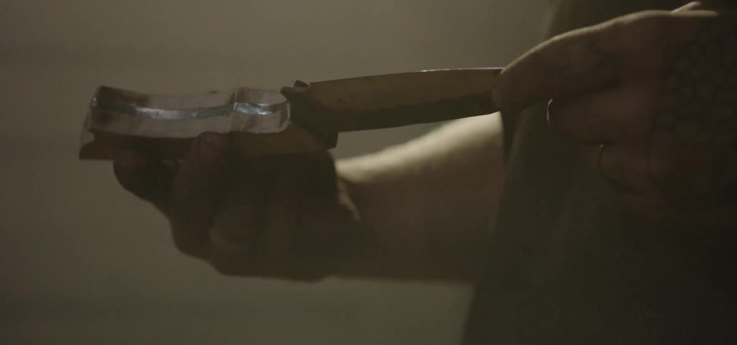 A man inspects the blade and handle of a knife