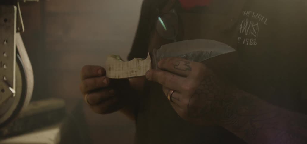 A man closely examines a knife in his hands