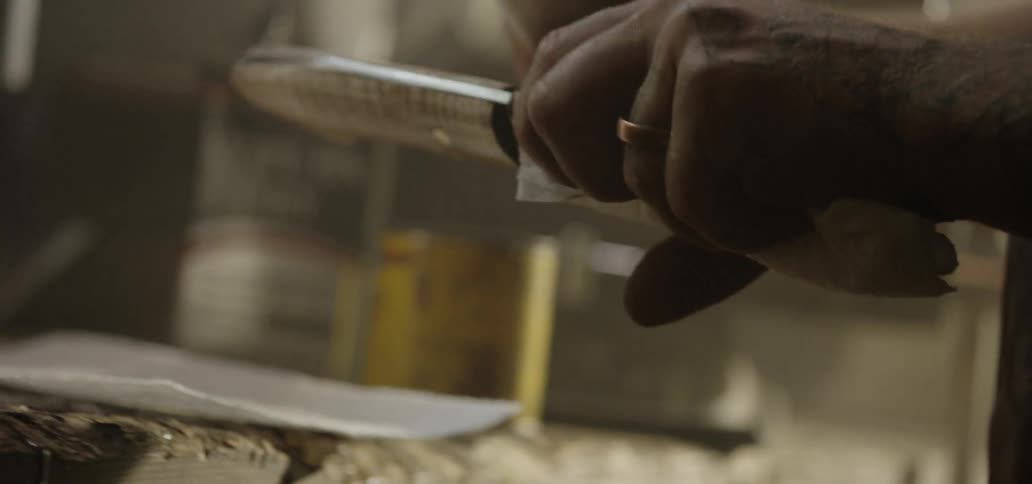 A man holds a knife and polishes the handle