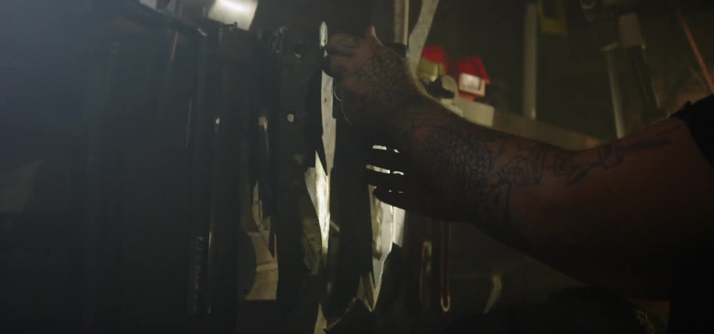 A persons arms with tattoos sorting blades for knives