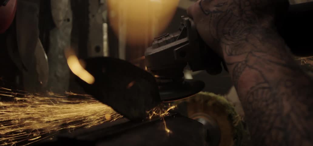 A man using an angle grinder on a piece of metal