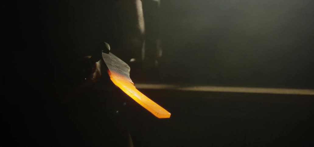 Steel worker taking out a piece of molten metal out of the oven