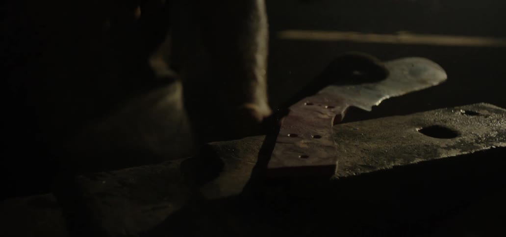 A blacksmith hammers metal as he shapes a knife