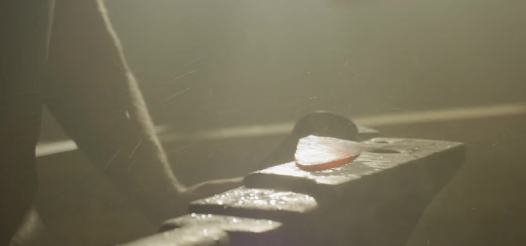 A blacksmith hammers on hot metal
