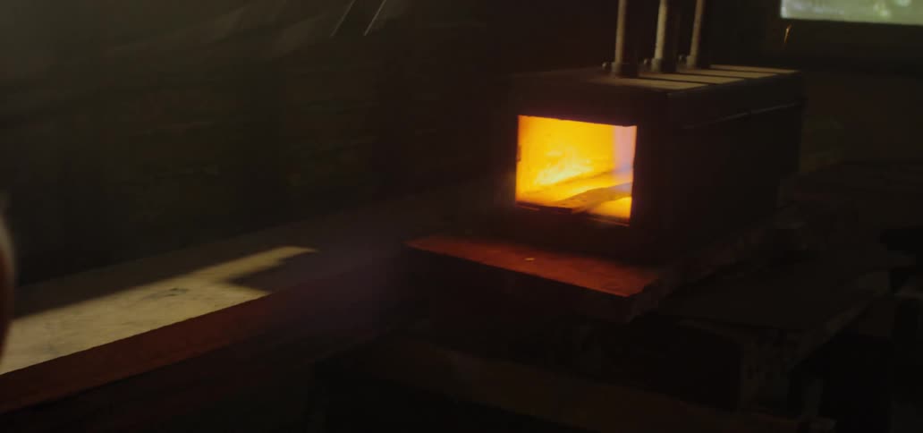 Sparks fly as a blacksmith places metal in glowing hot forge