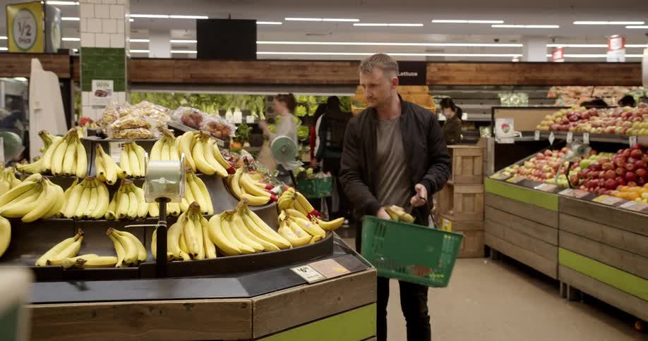 Man shops in produce section of grocery store