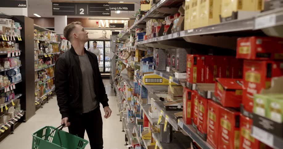 Man selects items off the shelf in grocery store