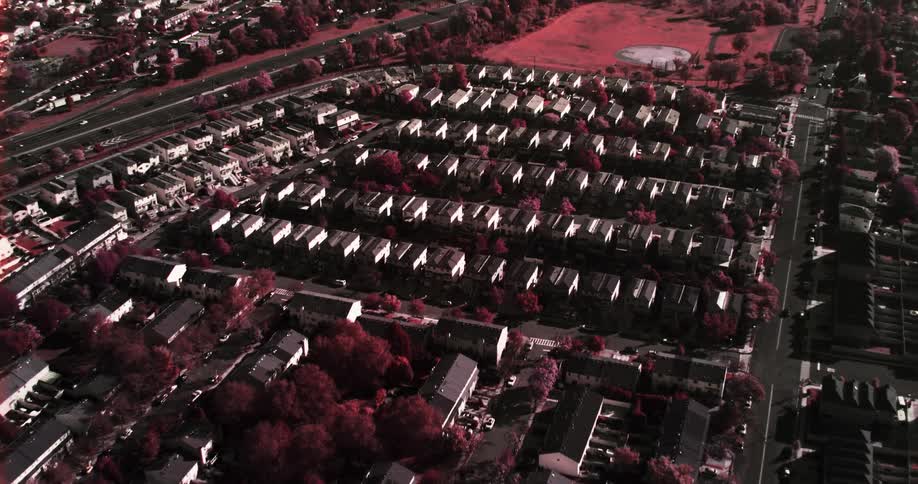 A large suburban neighborhood surrounded by trees and highway