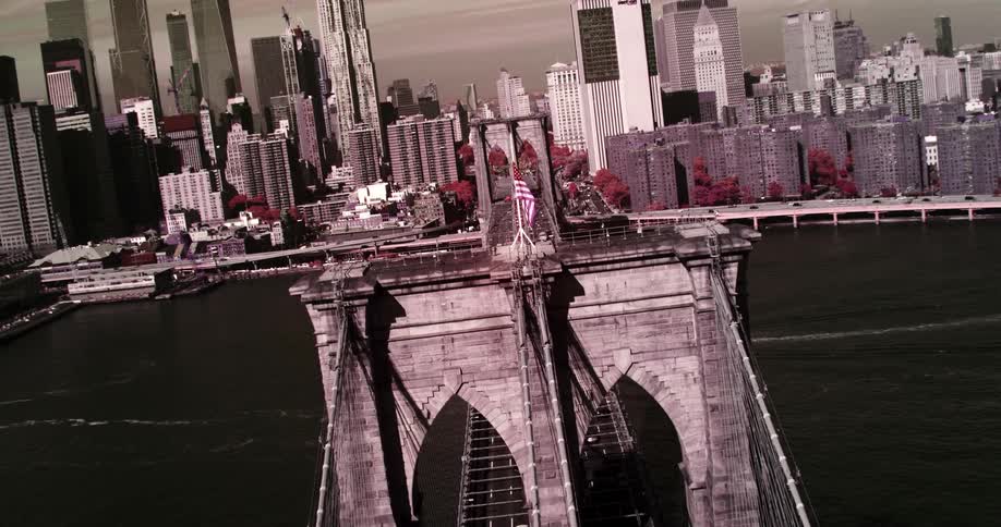 An aerial view of a bridge with an american flag in a large city