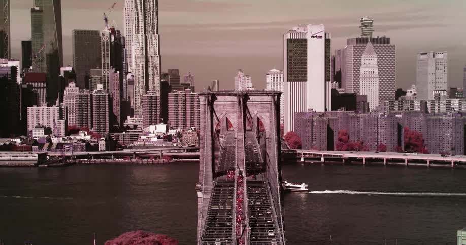 A bridge over the river with a boat and the city skyline in the background