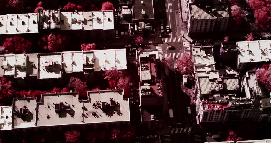 An aerial view from overhead shows the roofs of many tall residential buildings