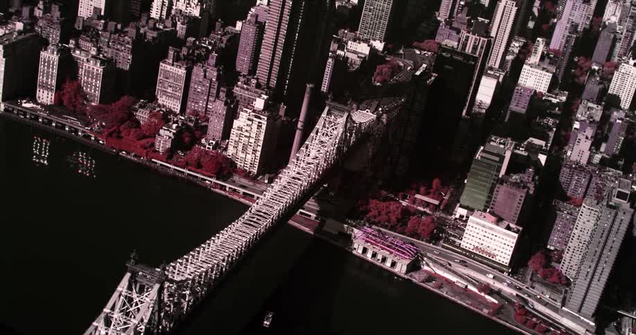 Black and white aerial view of a bridge leading into a downtown city