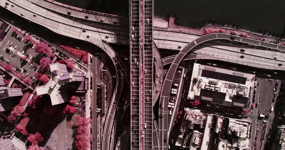 A bridge over a river in a city with roads and vehicles