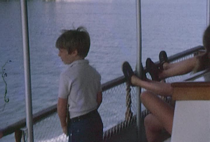 Little boy watches the water while riding on a ferry