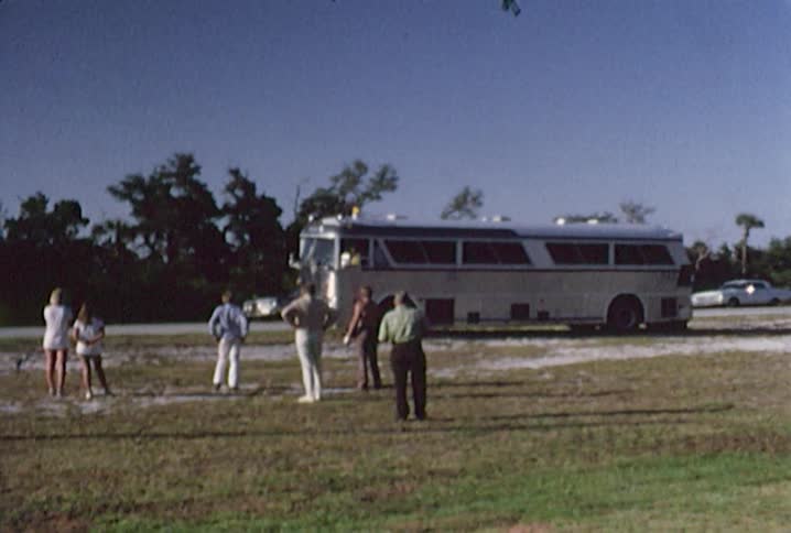 People watch as a bus is towed out of the mud