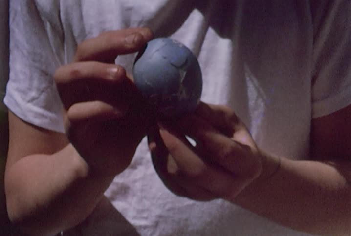 Old footage of people holding easter eggs that have messages written on them and boys sitting at a picnic table