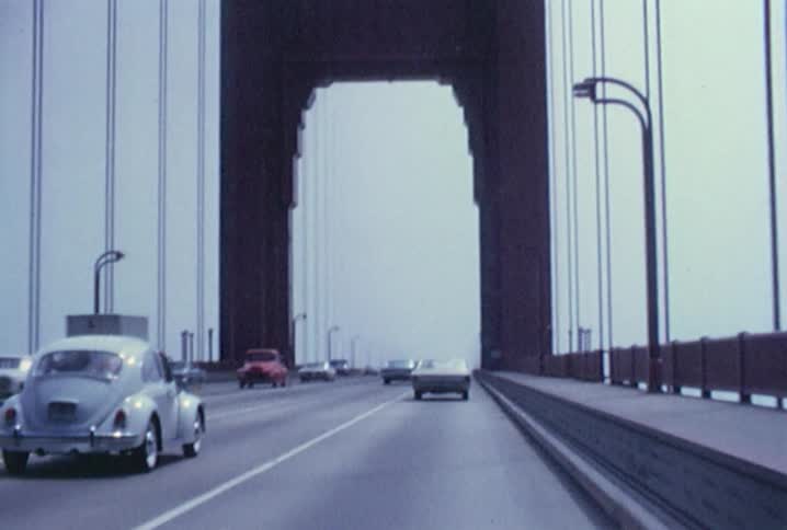 Cars are traveling over a bridge on a cloudy day