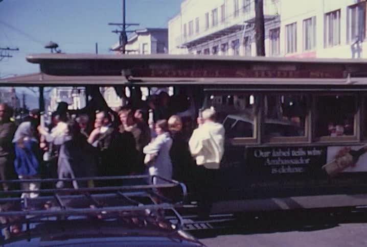 People riding a crowded trolley