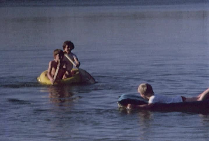 Boys float on rafts in water
