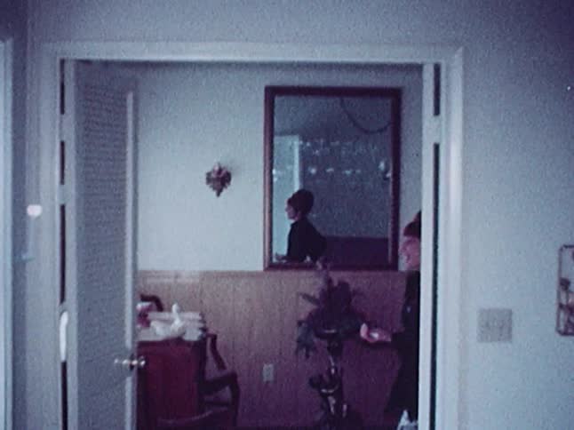 Woman waving hello as she opens the door