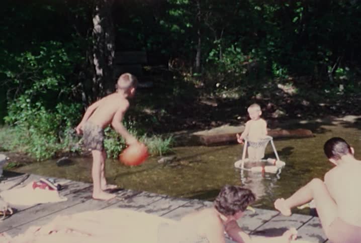 A boy tosses a ball into a lake