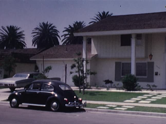 White house with two cars sitting in front of it