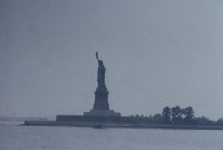 A wide shot that zooms in on the statue of liberty