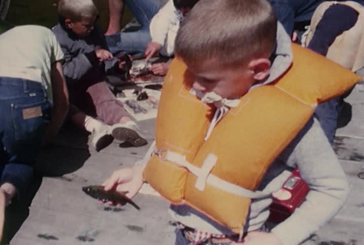 Some are gutting fish while one child holds his fish