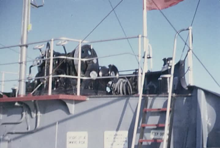 View of children sitting in an old station wagon that is parked on a ferry travelling across a large body of water