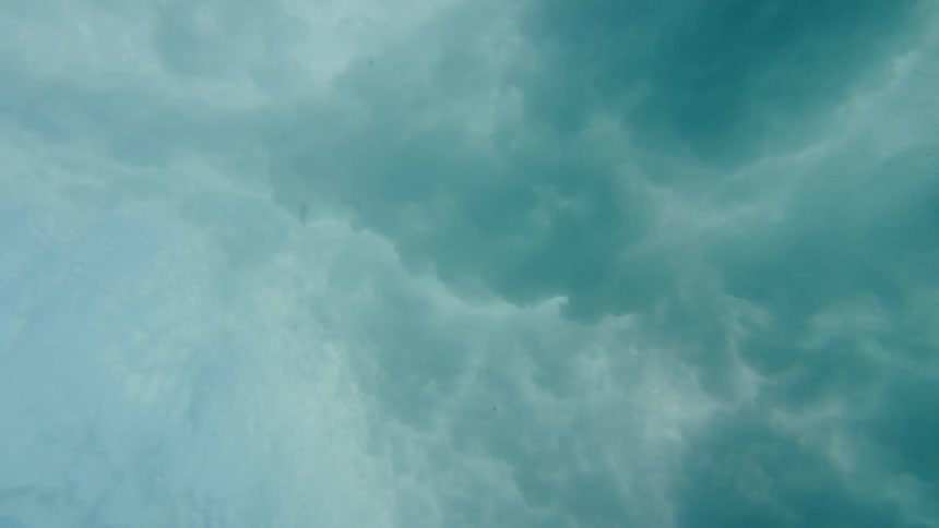 Waves crash in the ocean as seen from underwater