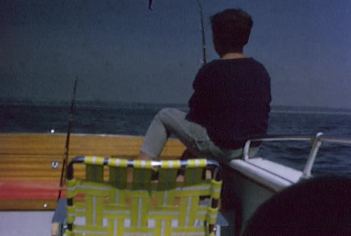 Young boy fishing on a boat while another plays with a lock